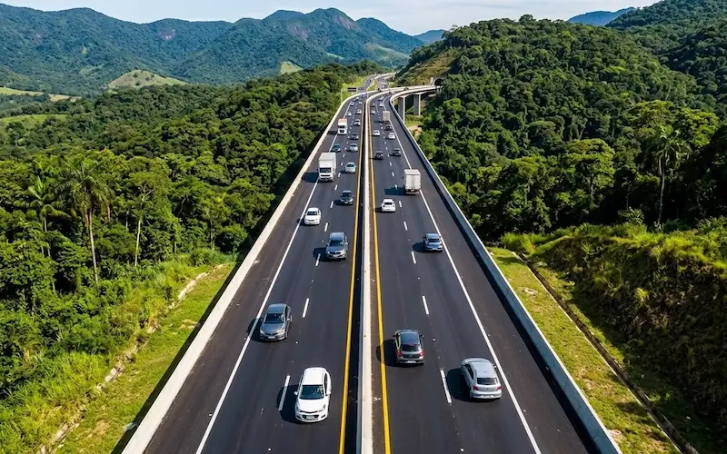 Vista aérea de carros circulando em uma rodovia brasileira moderna e bem sinalizada.